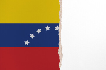 Half- ripped paper background in colors of national flag. Venezuela