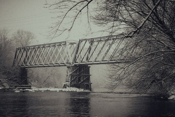 Grayscale shot of a bridge over a river in Menomonie, Wisconsin - obrazy, fototapety, plakaty