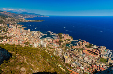 Fototapeta na wymiar Aerial view of principality of Monaco at sunset, Monte-Carlo, luxury buildings, soccer stadium, view of city life from La Turbie mountain, a lot of mega yachts and boats, water horizon 