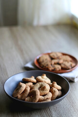 Obraz na płótnie Canvas Plate of chocolate chip cookies and bowl of sugar cookies on wooden table. Selective focus.