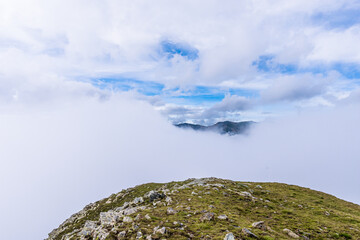 Mountain landscape with soft white clouds.