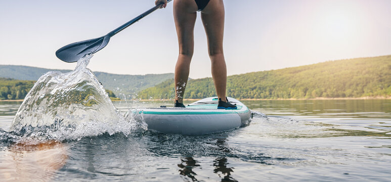 Sporty girl stand up paddle surfing 