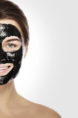 Woman with deep cleansing black mask on her face