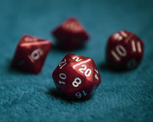 Selective focus of a set of red dice with numbers, on a blue fabric