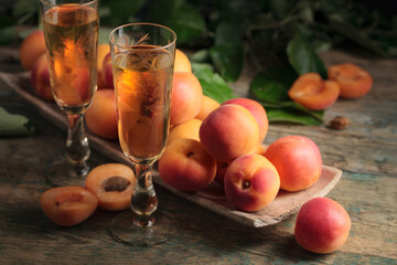 Fresh apricots with leaves and glasses of sweet wine.