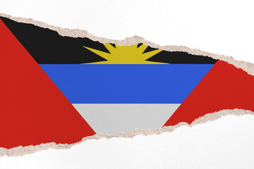 Ripped paper background in colors of national flag. Antigua and Barbuda
