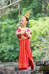 Asian young girl wearing typical, traditional Thai Dress. Red and gold traditional dancing.
