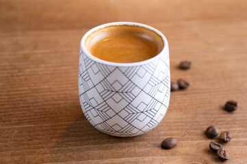 taza de café mexicano en mesa de madera conngranos de café