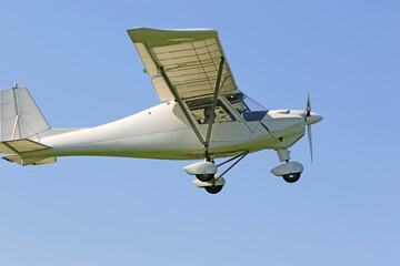 Ultralight airplane flying in a blue sky	