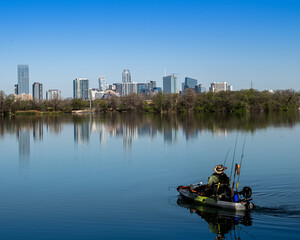 Beautiful view of a man with Kayak fishing on lake near downtown Austin Texa