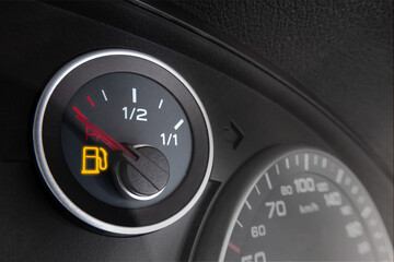 Close-up shot of glowing fuel gauge on the dashboard