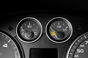 Close-up shot of glowing fuel gauge on the dashboard