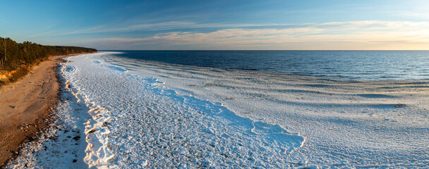 Scenic landscape of shore of Baltic sea at winter. Snow on sand.