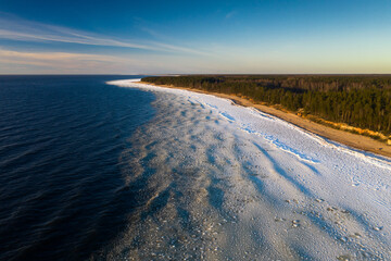 Scenic landscape of shore of Baltic sea at winter. Snow on sand.