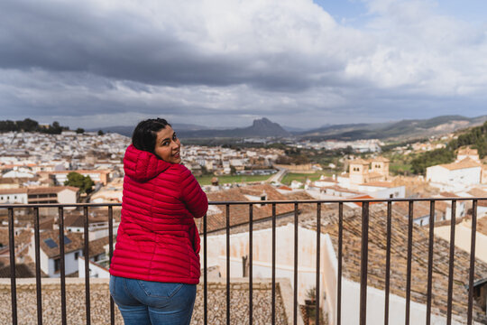 Young Tourist Female In A Red Jacket Posing Over A View Of A City