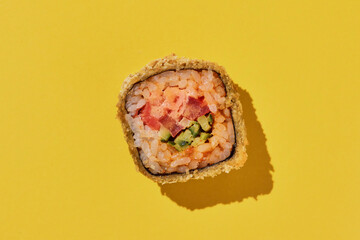Hot sushi roll with shrimp on yellow background.