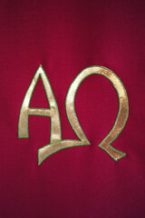 Vertical shot of an Altar cloth with embroidered gold Christian Alpha and Omega symbols