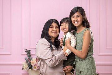 Fototapeta premium Mexican mother with hugging and laughing with her two children