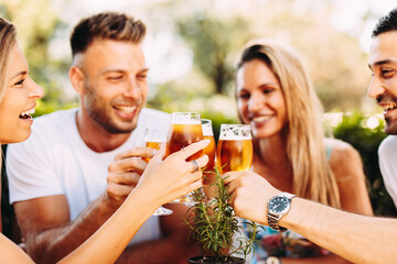 Group of happy friends toasting with beer. Selective focus on beer