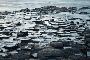 Closeup shot of the water washing basalt rocks at the Giants Causeway in Northern Ireland