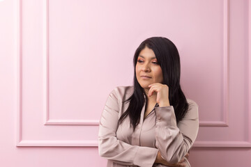 portrait of a mexican empowered woman isolated on pink background