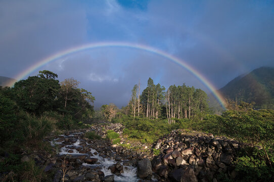 Tropical landscape image showing a river framed by a double rainbow after a rainstorm. Image taken in Boquete, Panama.