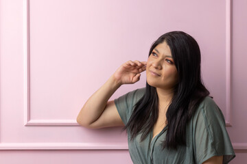 portrait of a mexican empowered woman isolated on pink background