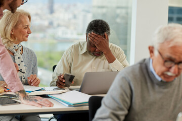 Fototapeta premium A senior african man having trouble learning the use of the internet on the course for senior people in the classroom.