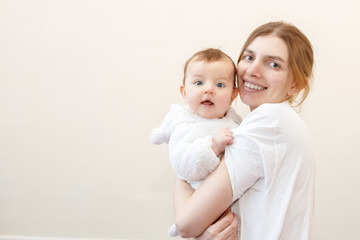 a young mother and baby look and smile. free space for text