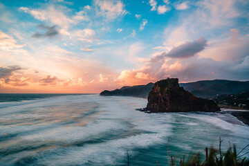 Scenic view of the rock formation and mountains against dusk sky, Piha Beach, Auckland, New Zealand