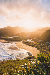 Beautiful landscape of Piha Beach and mountains against dusk sky at sunset in Auckland, New Zealand