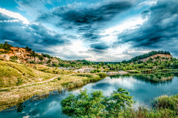 Scenic view of the hills and the river with reflection against cloudy sky