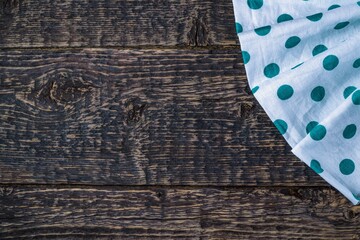 White cloth napkin in a green circle on the texture of old wood. Flat lay, copy space