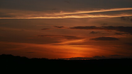 Romantischer Sonnenuntergang im Norden mit Wolken und orangenen und roten Farben