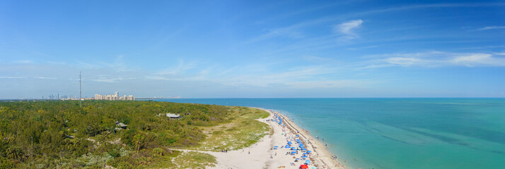 Aerial view of the beautiful sandy beach on the coast gleaming under the cloudy blue sky