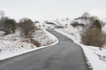Winter landscape with a road winding between hills - 498601252