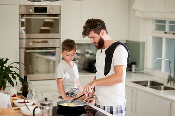 And thats the secret to fluffy scrambled eggs. Shot of an adorable little boy and his father making...