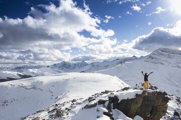 Aerial view of a hiker enjoying the view on the snowy Bald Hills, Jasper, Alberta, Canada