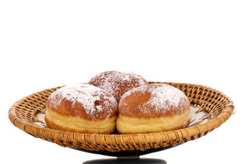 Three sweet donuts stuffed with jam on a ceramic dish, macro, isolated on a white background.