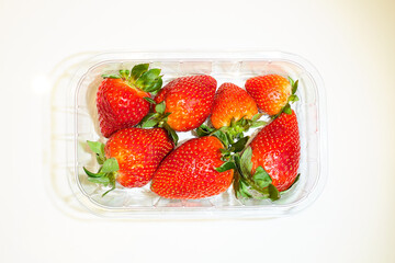Strawberry fruits in plastic box on white background