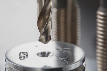 metal drill bit make holes in aluminium radiator on industrial drilling machine. Metal work...