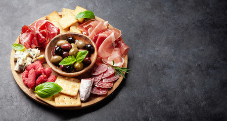 Antipasto board with prosciutto, salami, crackers, cheese, olives
