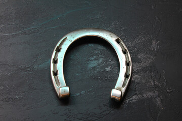 Metal gray horseshoe on a black surface