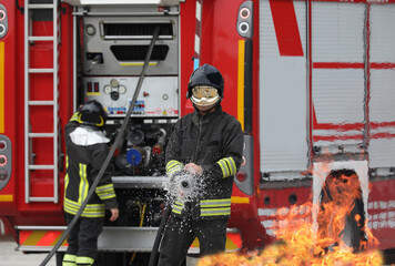 firefighter during a drill extinguishes the fire and the fire truck