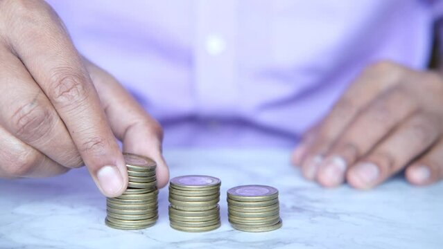 man's Hand putting stack of coins