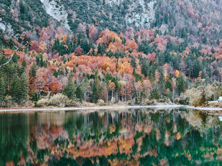Bergsee geschossen mit Herbstbaumreflexionen auf einem Wasser © Wirestock Creators