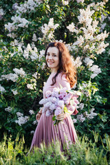 beautiful woman with a bouquet of lilac flowers in spring