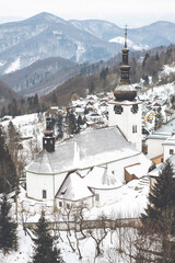 Vertical shot of a church in Spania Dolina, Slovakia in winter - obrazy, fototapety, plakaty