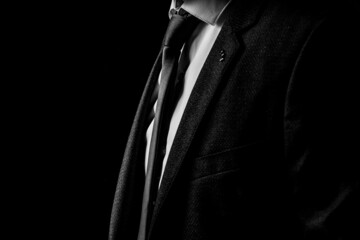 A man in a business suit in the dark black and white photo
