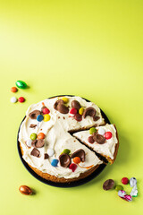Easter cake with chocolate eggs, candies and cream cheese frosting. Top view and copy space.